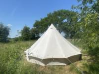 5m Bell tent with outdoor bed under a tree