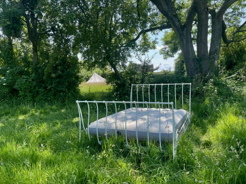 5m Bell tent with outdoor bed under a tree